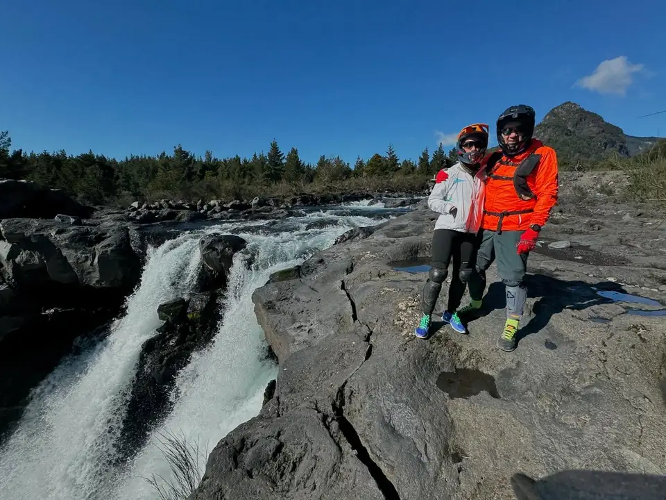 Pareja de ciclistas junto a una cascada en el Cerduo
