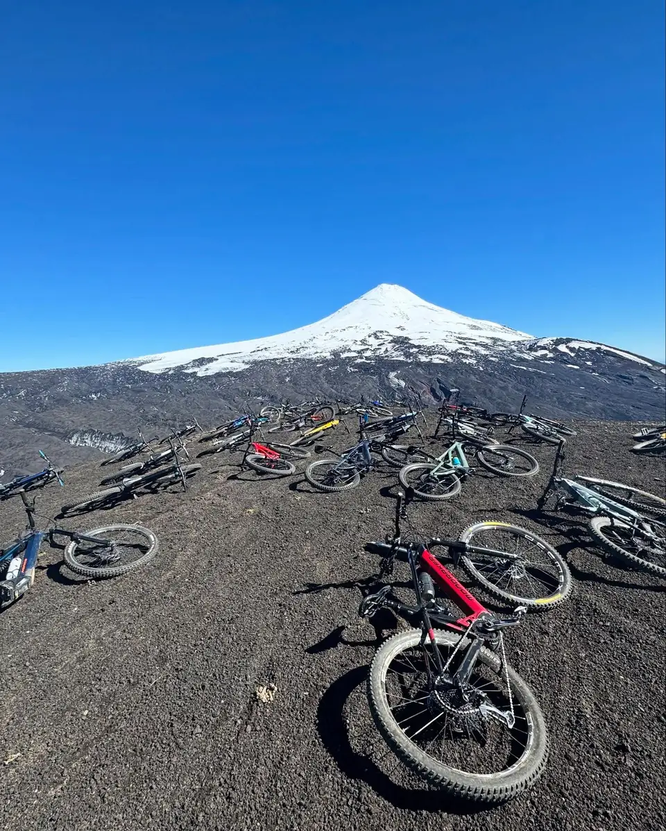 Grupo de ciclistas con el volcán Villarrica nevado de fondo