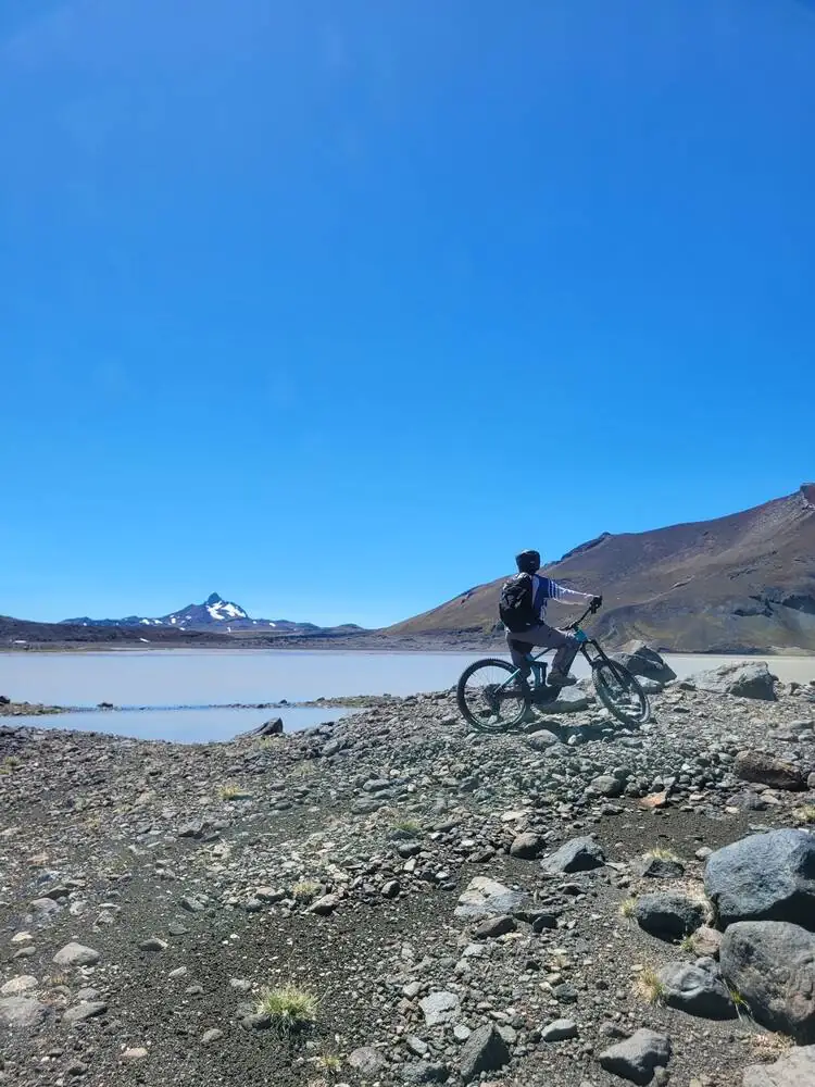 Ciclista frente a una laguna cordillerana